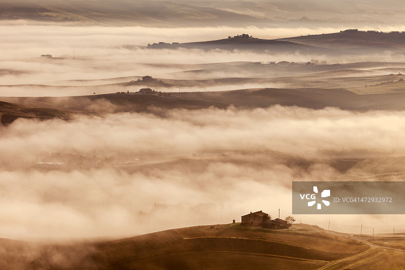 意大利托斯卡纳的丘陵、农舍和晨雾图片素材