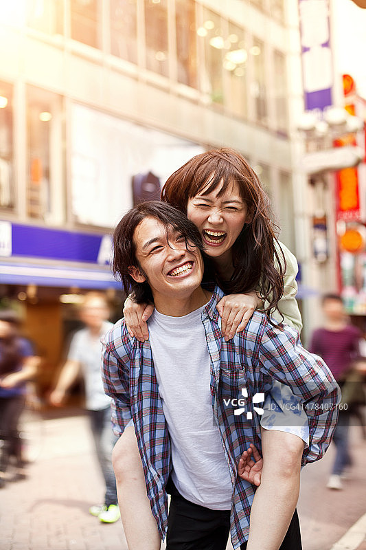 快乐的年轻亚洲夫妇有乐趣与pigback图片素材