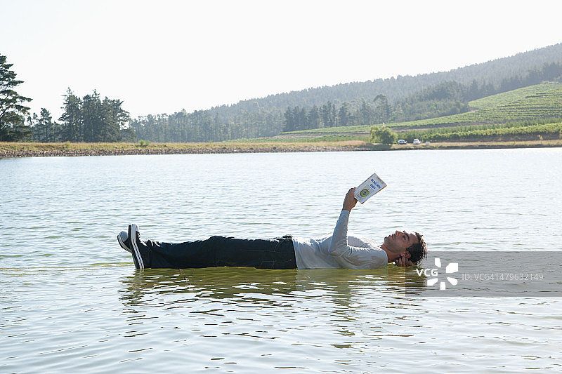 人躺在水里看书图片素材
