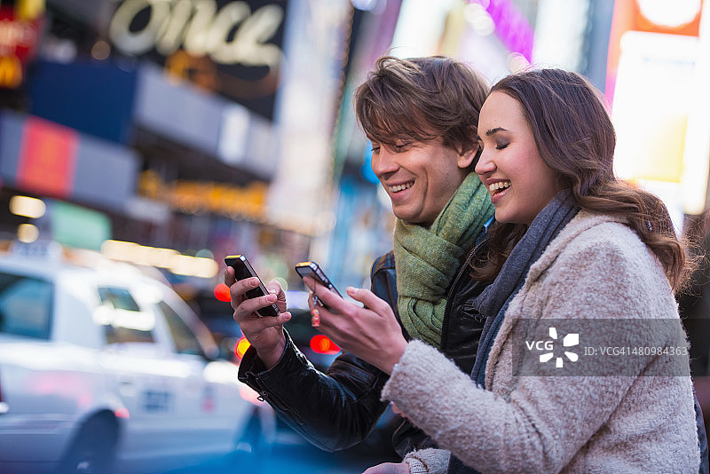 年轻夫妇在手机上竞争，纽约，美国图片素材
