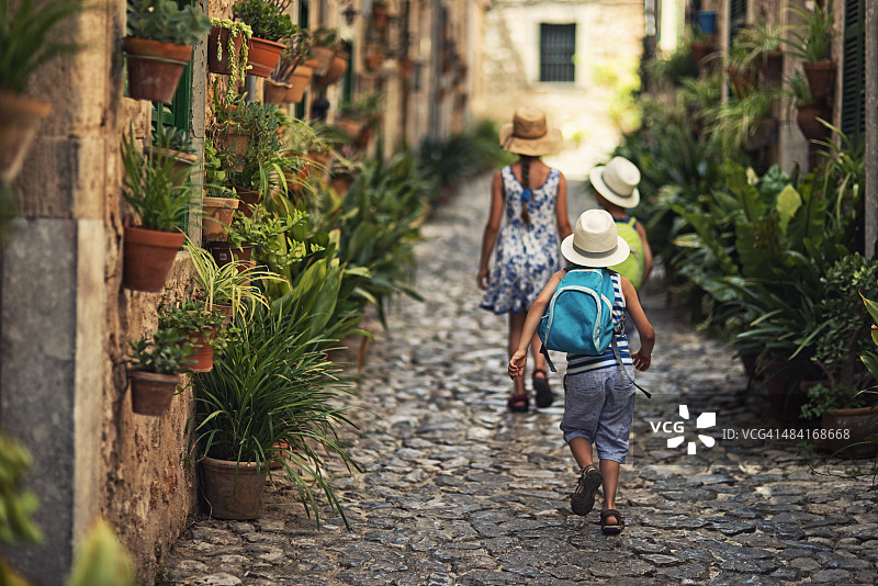孩子们走在地中海的街道上。图片素材