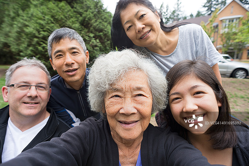 快乐的亚洲老女人与家人在公园自拍图片素材