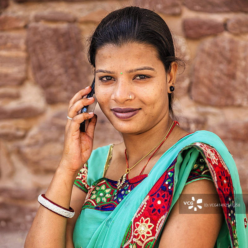 年轻的印度妇女使用手机，焦特布尔，印度图片素材