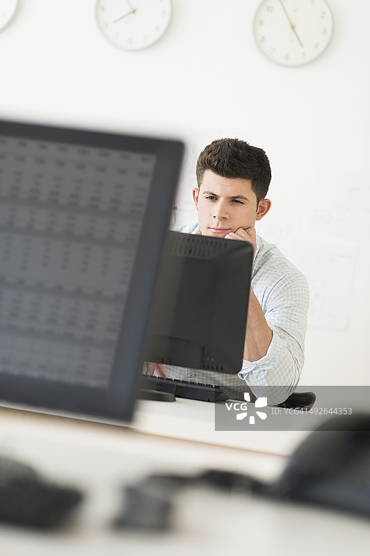 美国新泽西州泽西城，一个年轻人坐在办公桌前工作图片素材