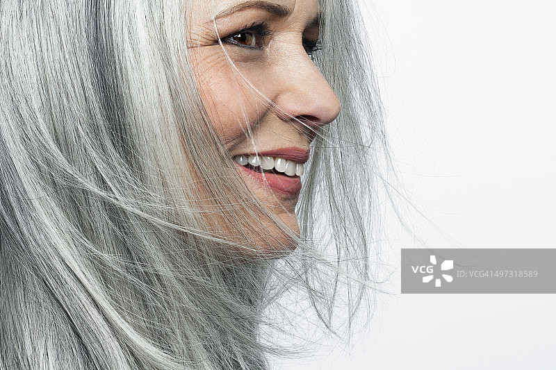 微笑灰白头发的女人，侧面。图片素材