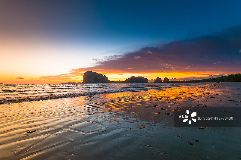 美丽的热带沙滩映衬着日落的天空。图片素材
