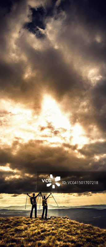 胜利的徒步者看着美丽的阳光照耀的云彩图片素材