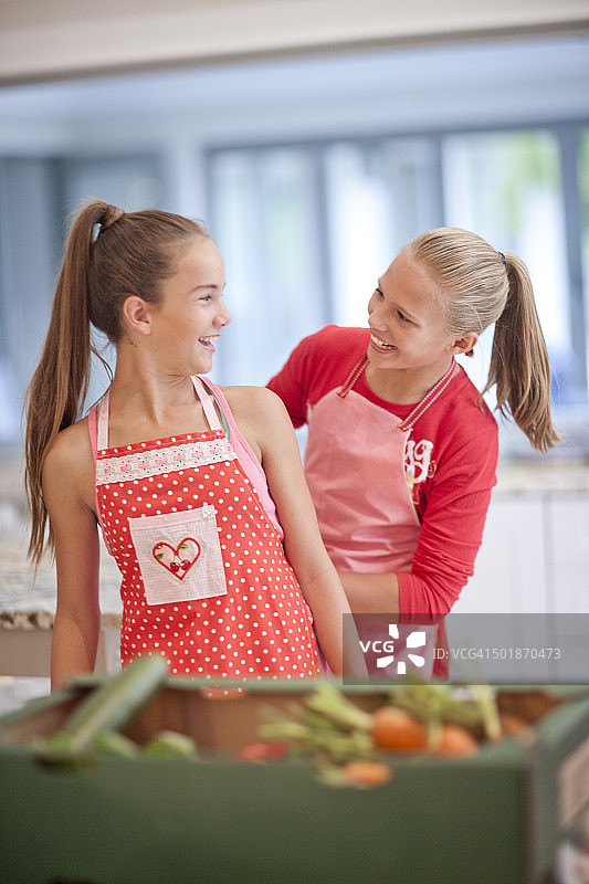 两个十几岁的女孩在厨房准备蔬菜图片素材