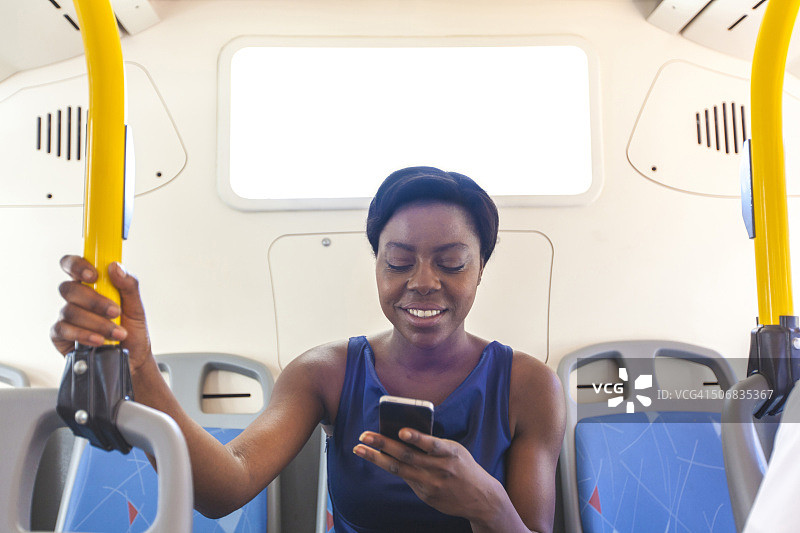 一位非洲女商人在南非开普敦的公交车上使用手机图片素材