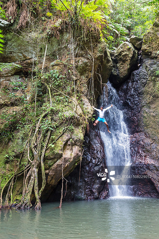 斐济，卡达武，一名当地人从瀑布上跳下图片素材