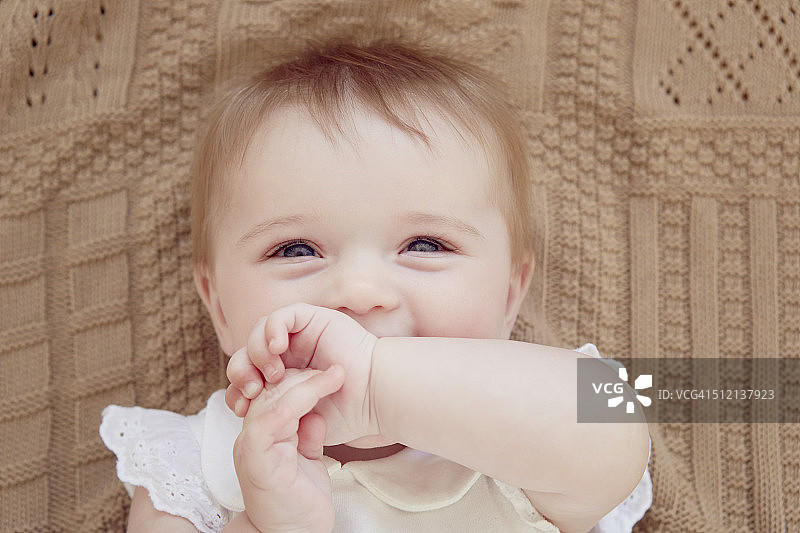 靠近肖像的微笑女婴躺在毯子上图片素材