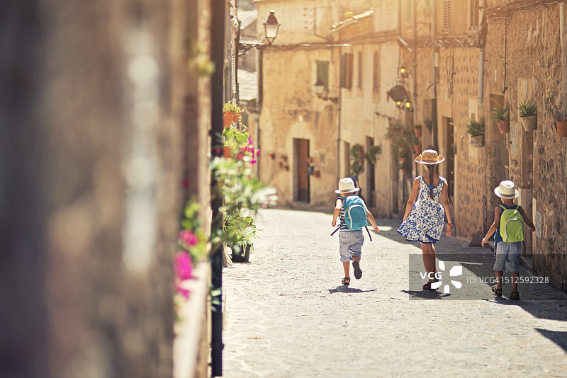 孩子们走在地中海的街道上。图片素材