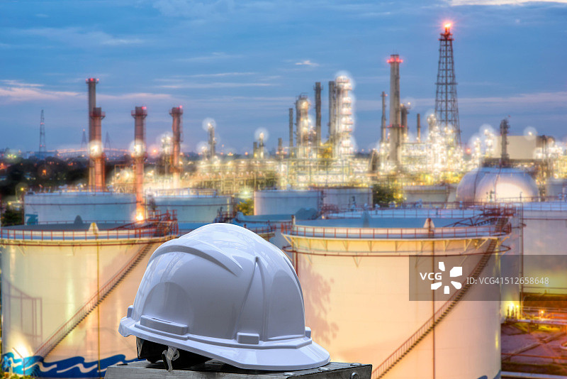 白色安全帽站在炼油厂前背景图片素材