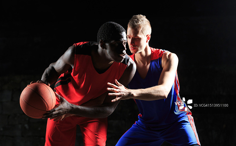 白人和非洲篮球运动员在黑人背景图片素材