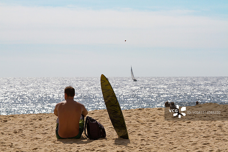一个在卡波圣卢卡斯有冲浪板的人图片素材
