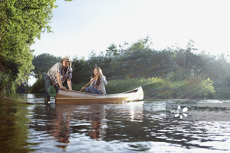 在河上划独木舟的夫妇图片素材