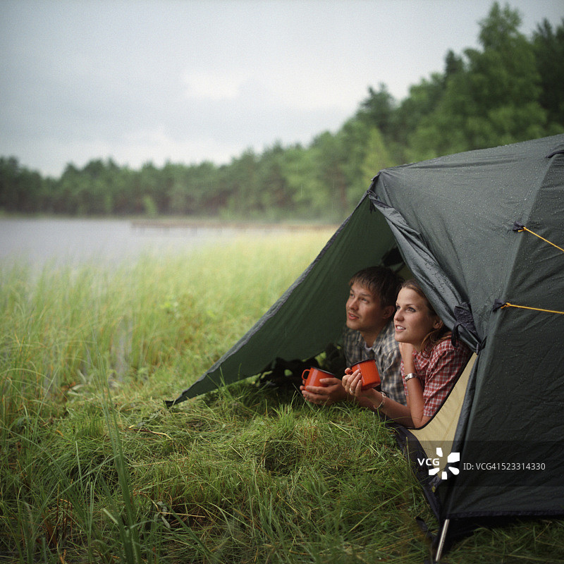 一对年轻夫妇在湖边的帐篷里图片素材