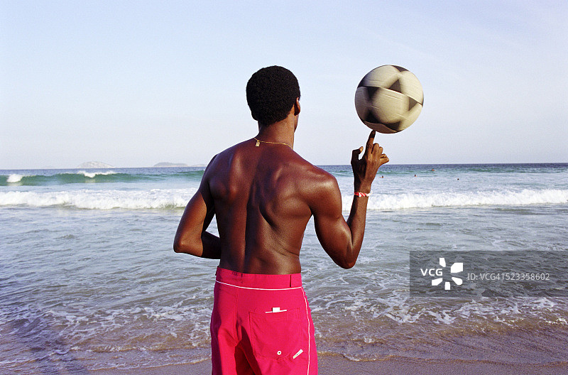 巴西里约热内卢，沙滩上的男人在踢足球图片素材