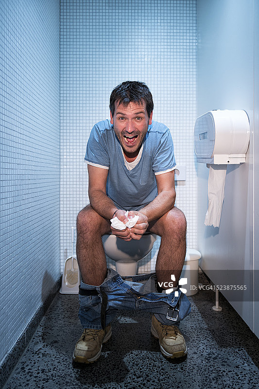 坐在公共厕所里的快乐男人图片素材
