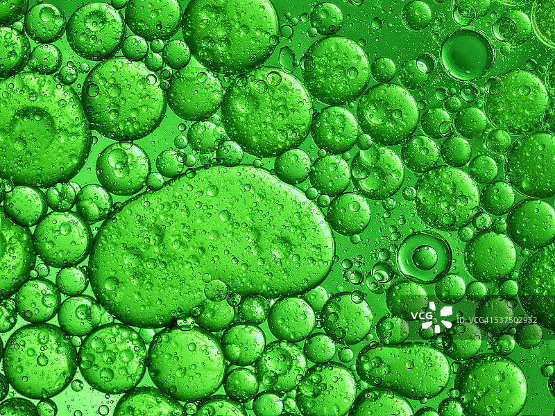油滴和气泡浮在水面上的绿色背景图片素材