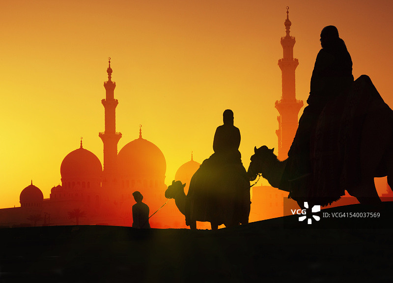 骆驼商队在日落时分到达一座清真寺图片素材