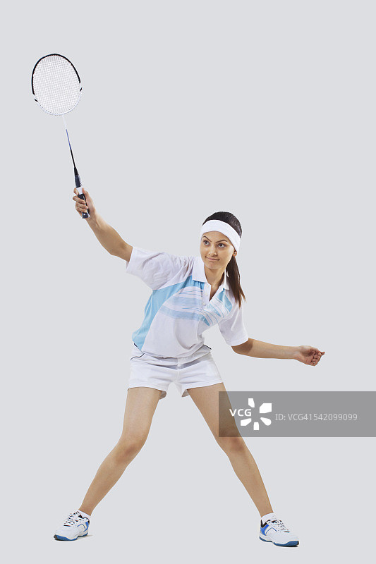 女子打羽毛球孤立的灰色背景图片素材