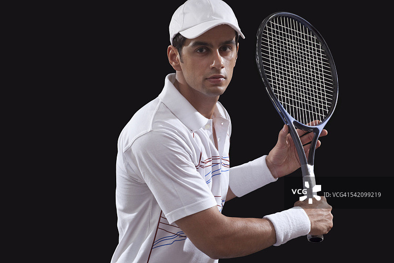 在黑色背景下打网球的男人的肖像图片素材