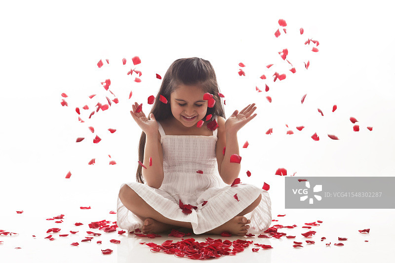 玫瑰花瓣落在一个小女孩身上图片素材