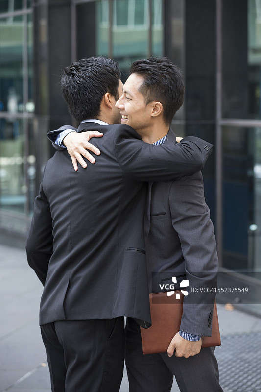 两个亚洲商人互相拥抱图片素材