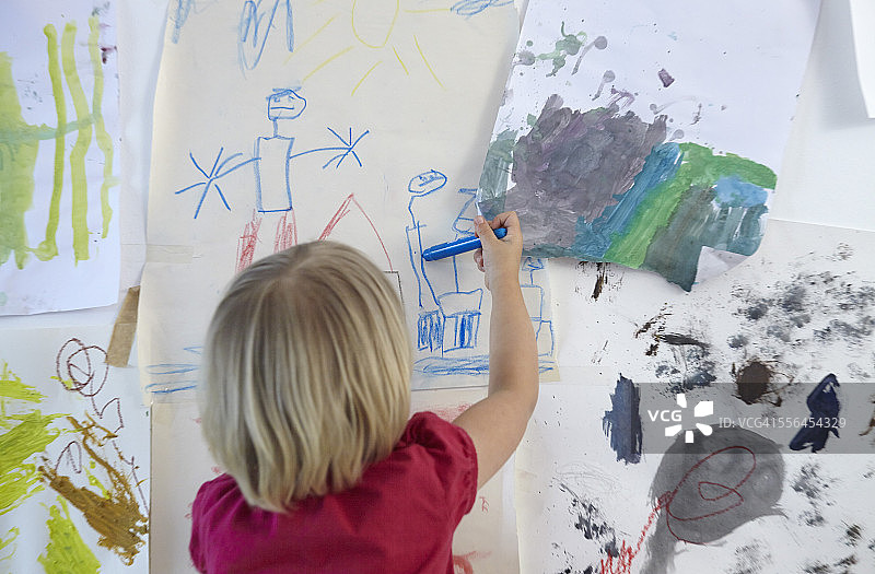 小女孩画在儿童房的墙上，后视图图片素材