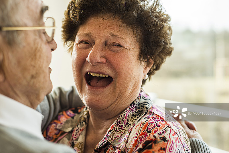 老女人在丈夫的怀抱里笑着图片素材