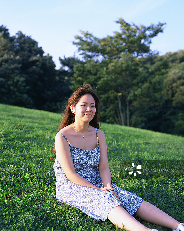 一个年轻女子坐在田野里图片素材