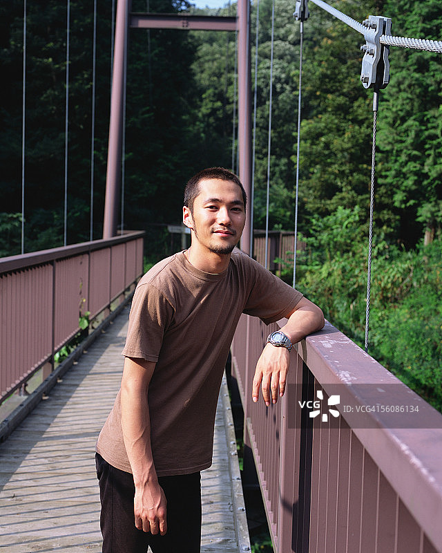 一个年轻人靠在桥上图片素材