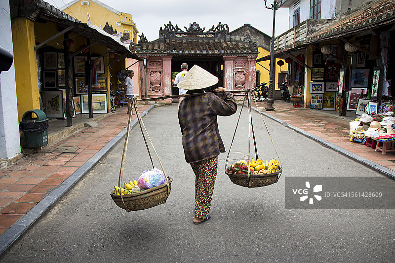 一名越南妇女在会安的街道上行走图片素材