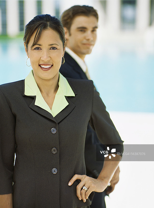 一幅女商人微笑的肖像，身后站着一位商人图片素材