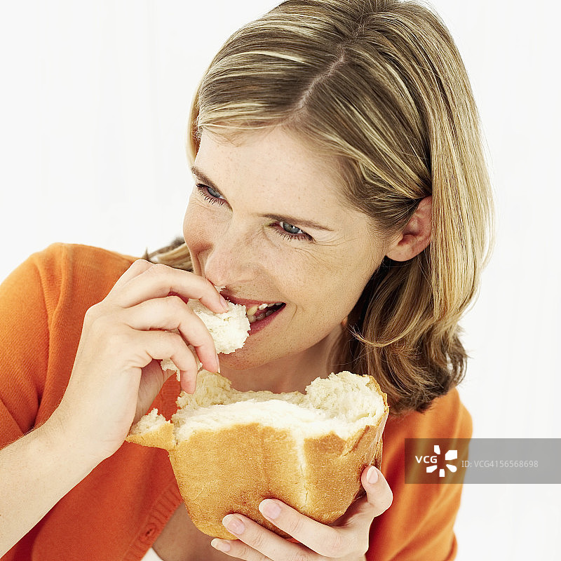 一个吃面包的年轻女人的肖像图片素材