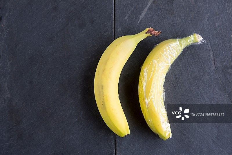 两个香蕉的静物——一个用保鲜膜包裹着图片素材