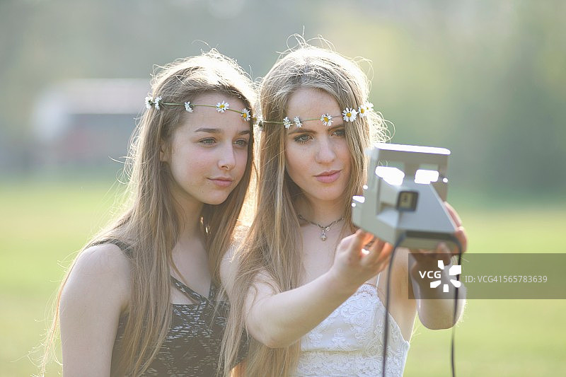两个十几岁的女孩在公园用相机自拍图片素材