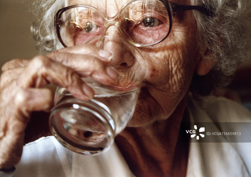老妇人喝了一杯水图片素材