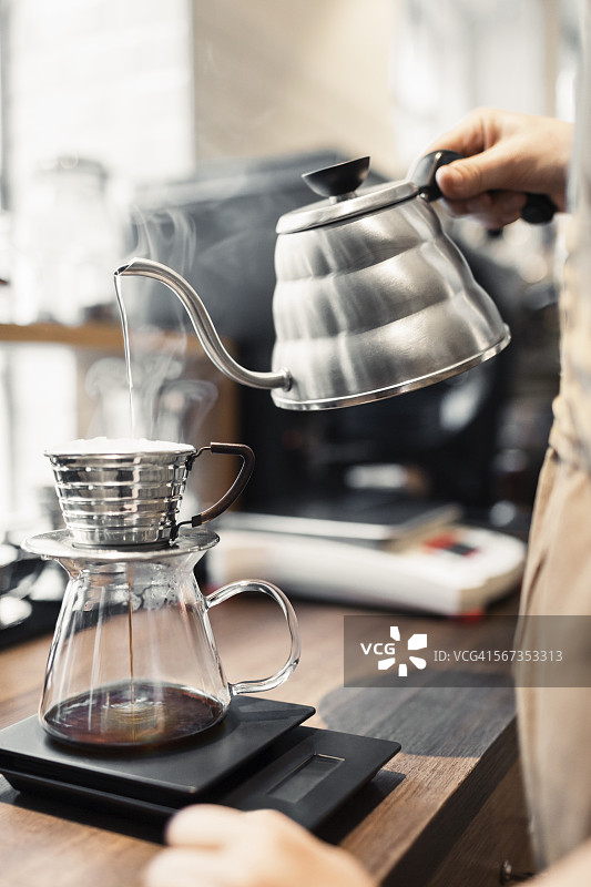 裁剪图像的咖啡师倒开水在咖啡过滤器图片素材
