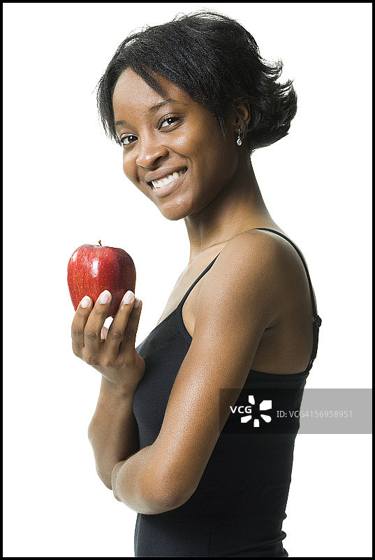 一个拿着苹果的年轻女人的侧面图片素材