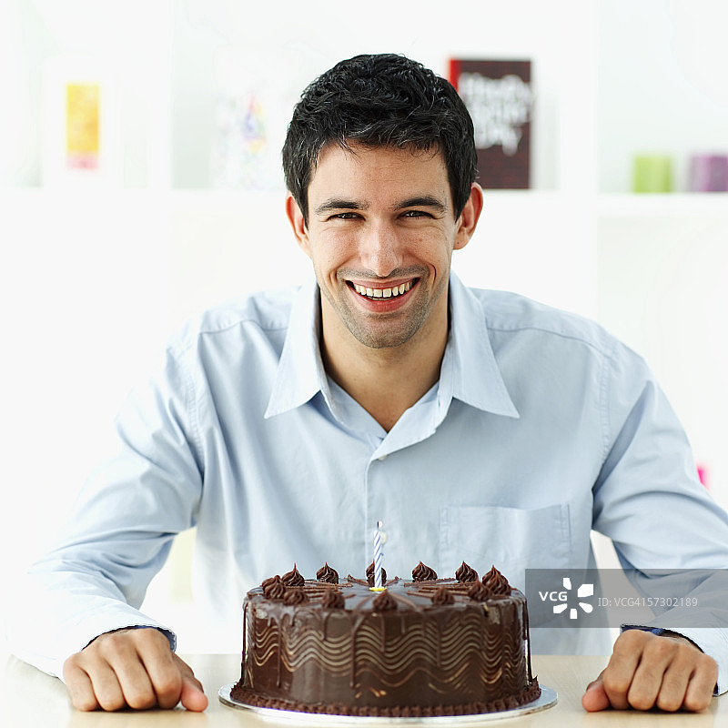 一个年轻人拿着生日蛋糕的肖像图片素材
