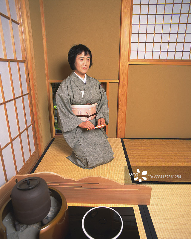 坐在茶馆nijiriguchi前的女人图片素材