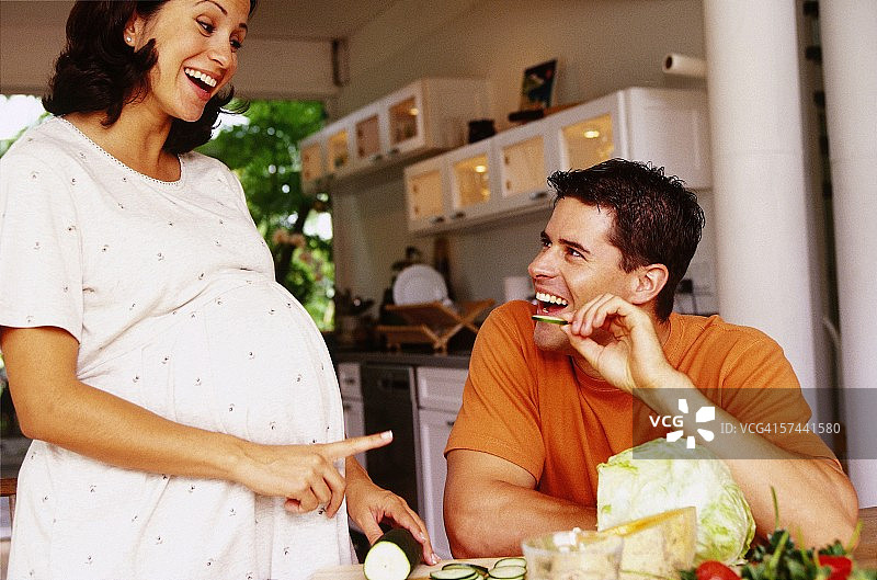 一个孕妇在餐桌上和她的丈夫说话图片素材