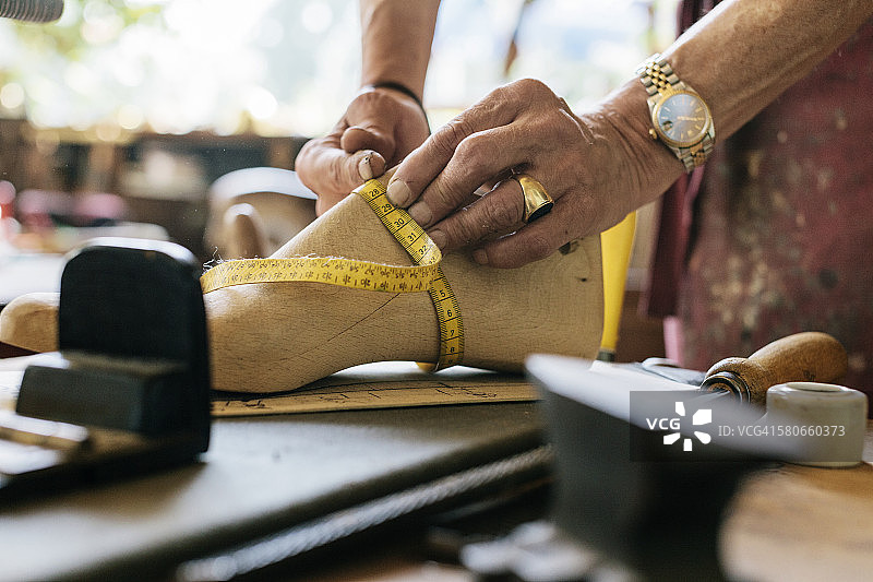 鞋匠测量木鞋的形状图片素材