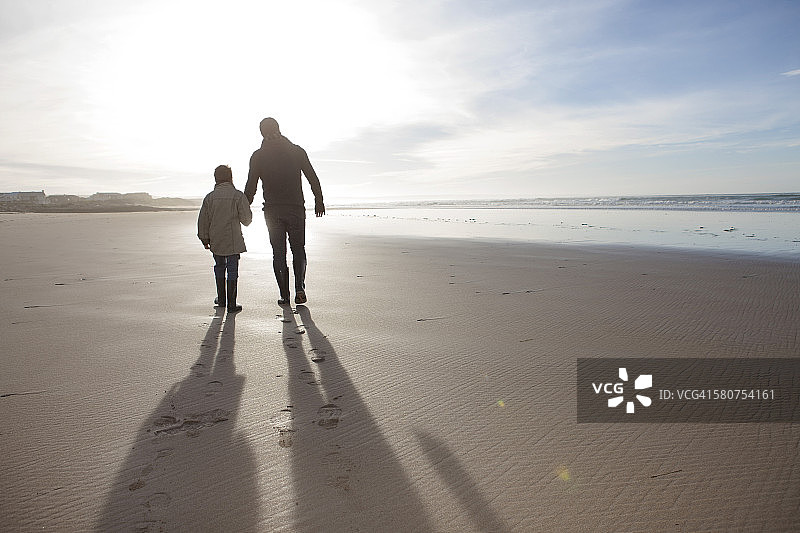 南非，Witsand，父亲和儿子走在海滩背光图片素材
