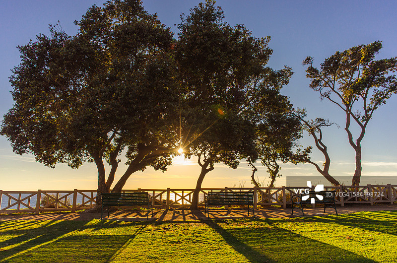 日落和公园长椅俯瞰海洋在圣塔莫尼卡图片素材