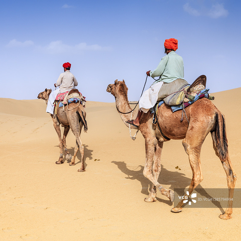 印度拉贾斯坦邦，在沙丘上骑骆驼的印度男人图片素材