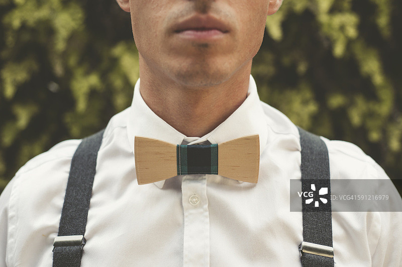 一个戴着木制领结的年轻人，特写图片素材