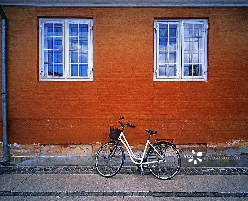 自行车靠在红砖墙上图片素材